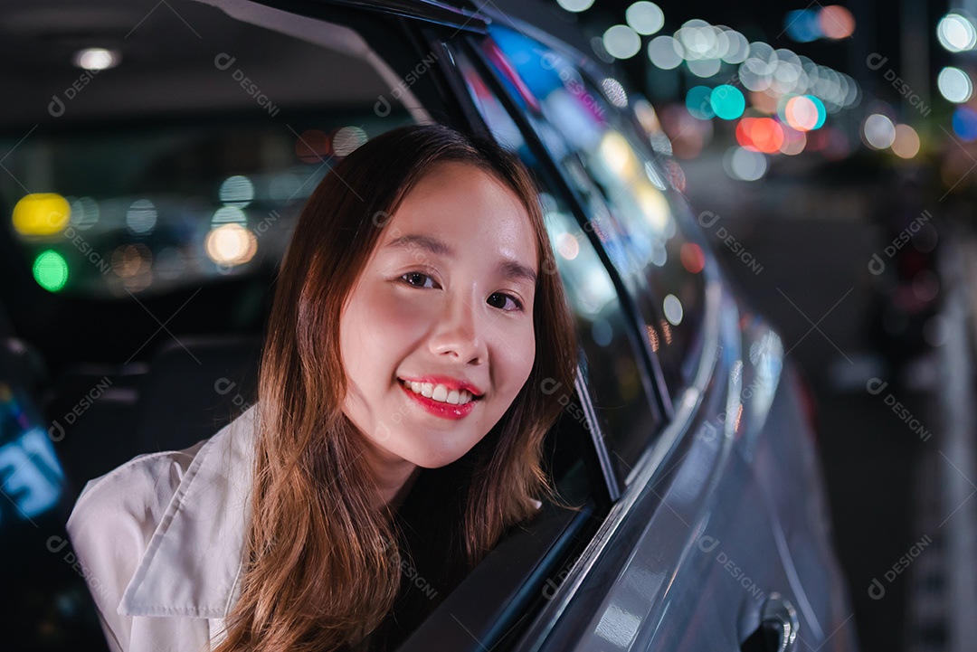 Empresária asiática de sucesso, sentada no banco de trás do carro