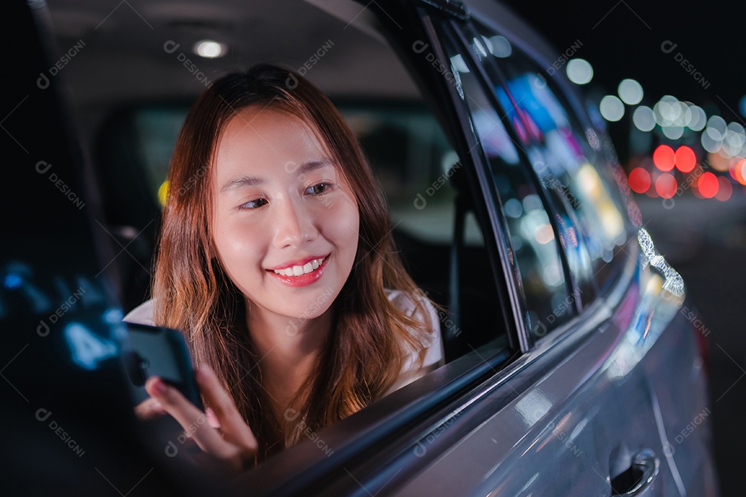 Empresária asiática de sucesso, sentada no banco de trás do carro