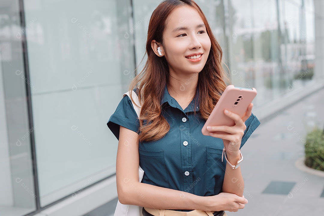 Empresária asiática usa fones de ouvido sem fio ouvindo música