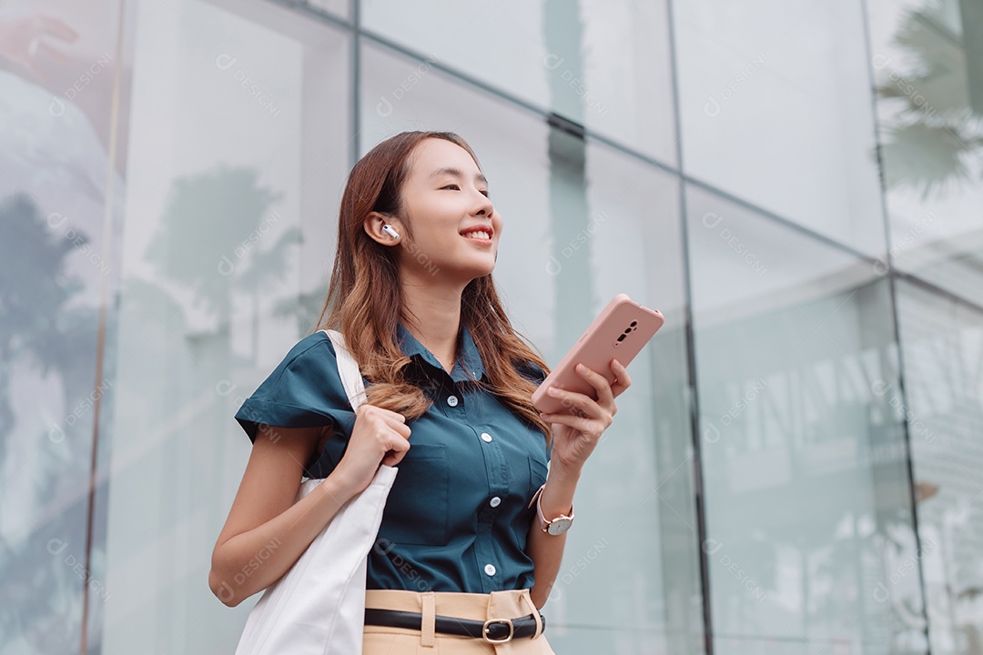 Empresária asiática usa fones de ouvido sem fio ouvindo música