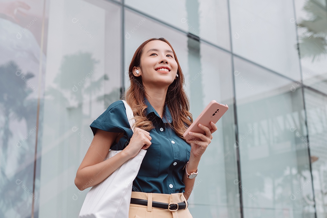 Empresária asiática usa fones de ouvido sem fio ouvindo música