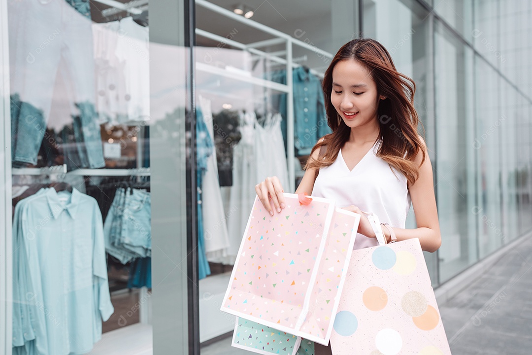 Linda mulher asiática segurando sacolas de compras