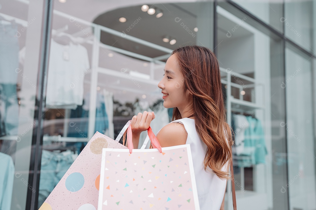 Linda mulher asiática segurando sacolas de compras