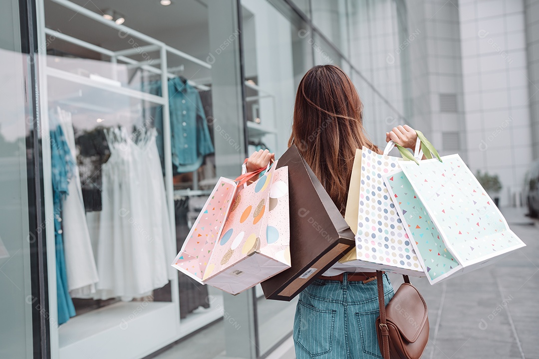 Linda mulher asiática segurando sacolas de compras