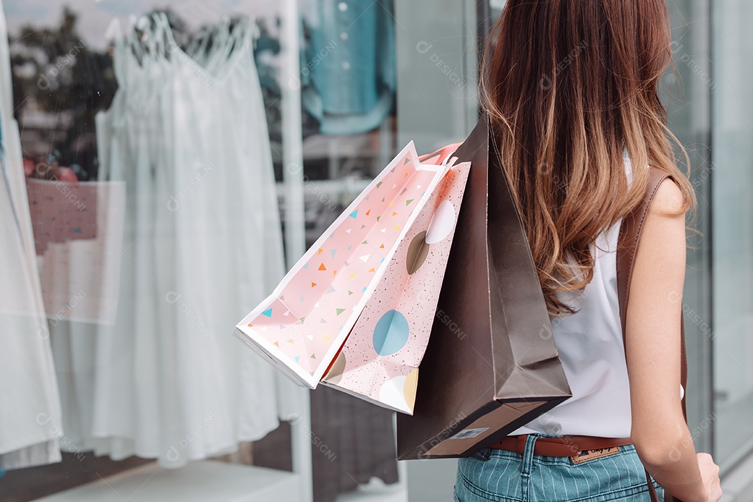 Linda mulher asiática segurando sacolas de compras