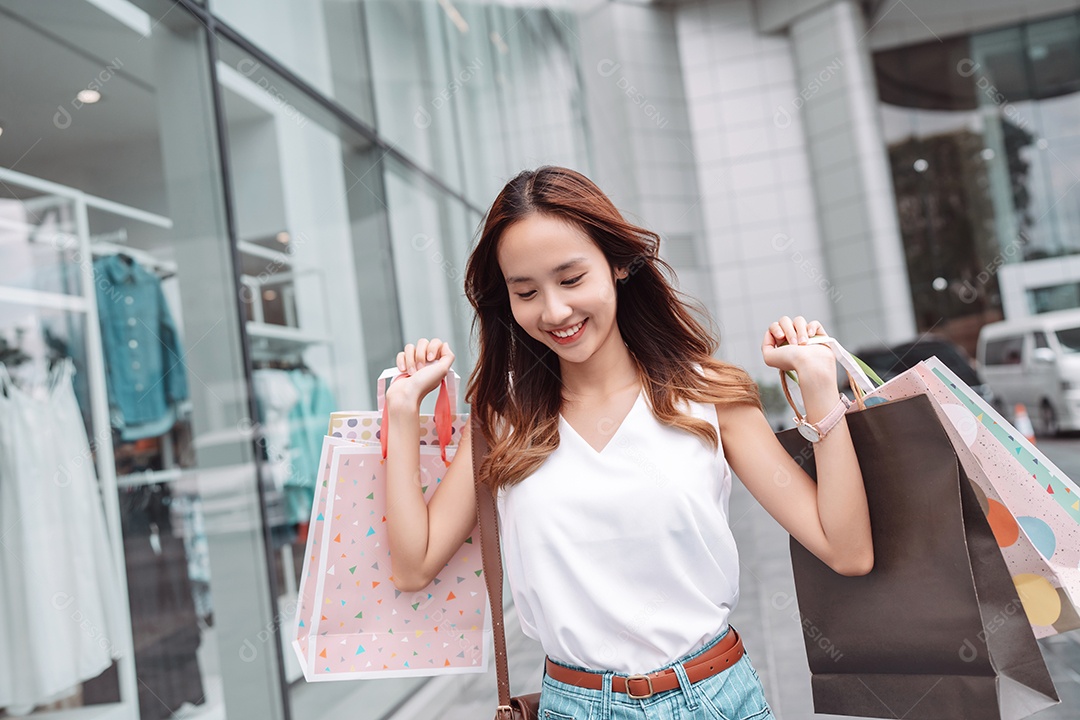 Linda mulher asiática segurando sacolas de compras