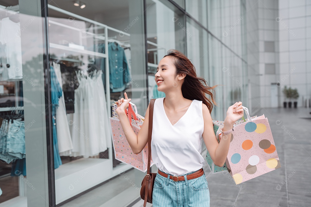 Linda mulher asiática segurando sacolas de compras