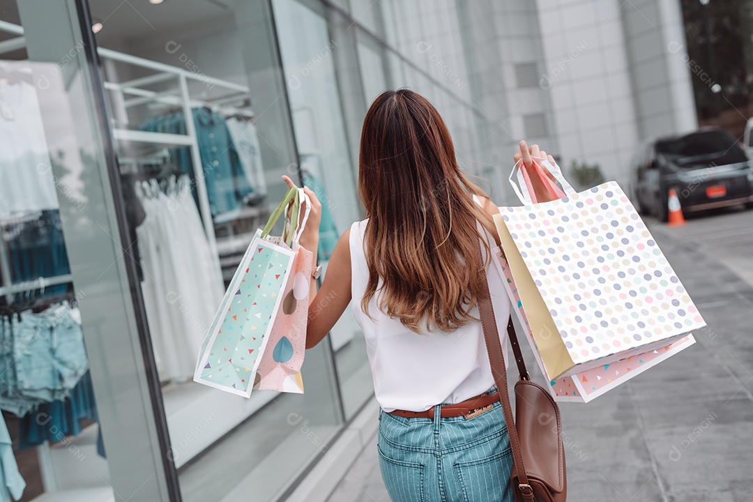 Linda mulher asiática segurando sacolas de compras