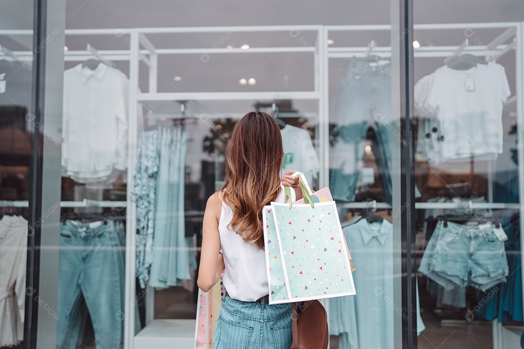 Linda mulher asiática segurando sacolas de compras