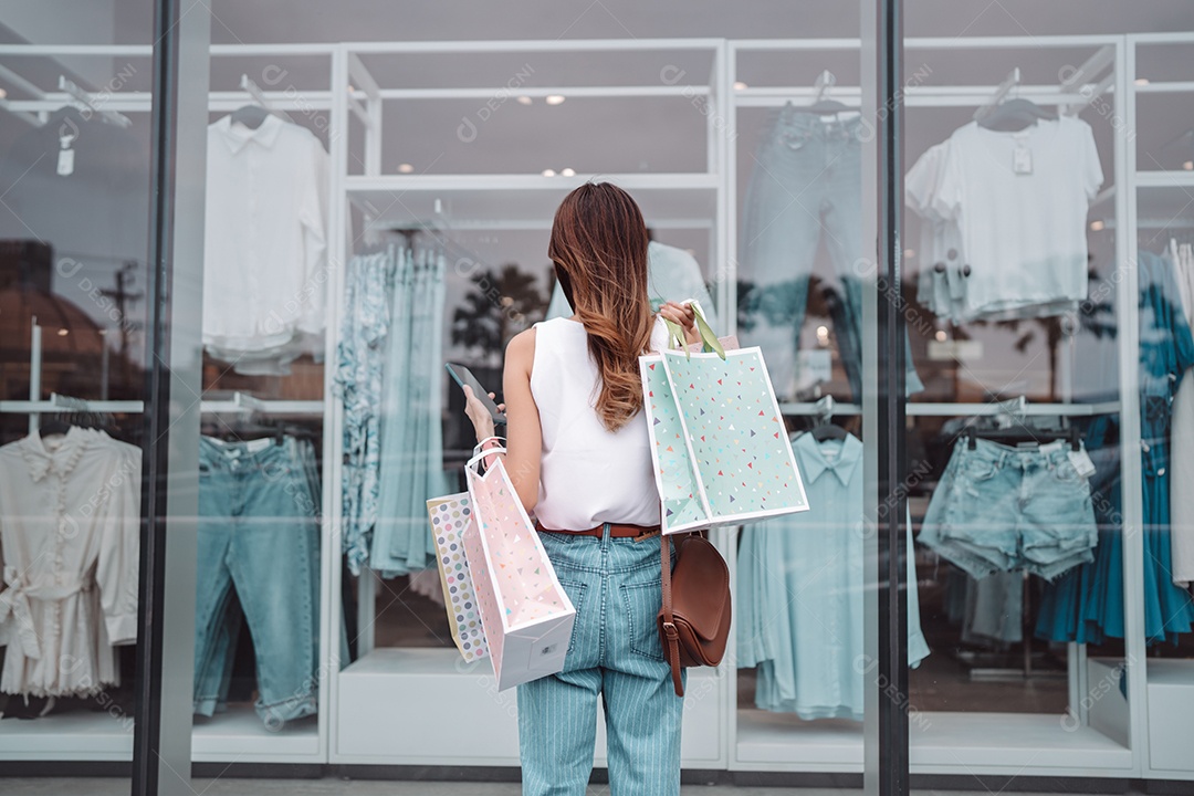 Linda mulher asiática segurando sacolas de compras