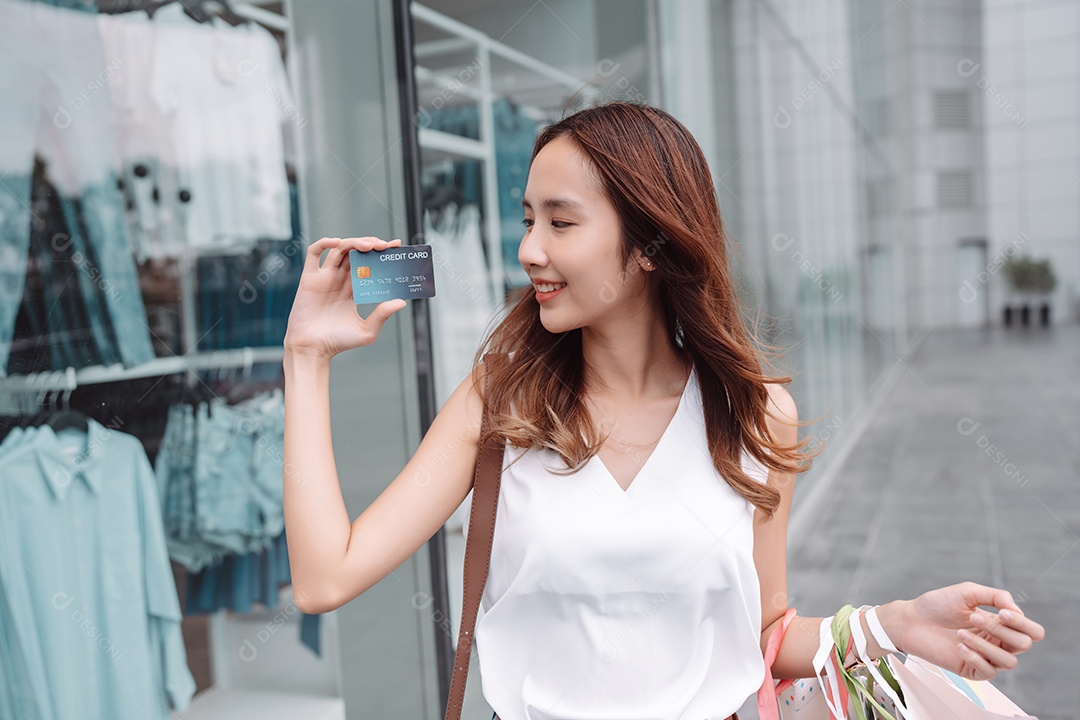 Mulher asiática cliente compradora mostrando cartão de crédito para pagamento