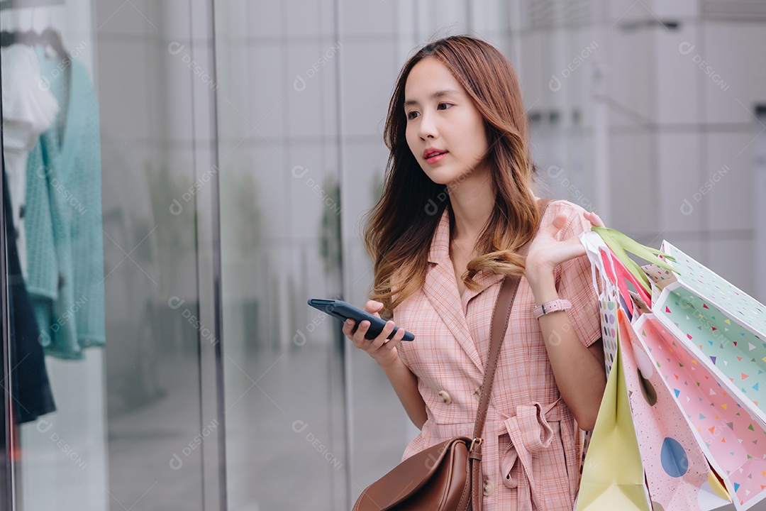 Mulher asiática cliente consumidora usando smartphone no shopping