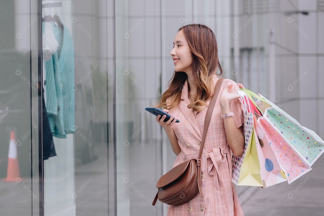Mulher asiática cliente consumidora usando smartphone no shopping