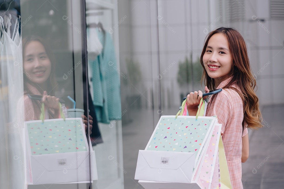 Mulher asiática cliente consumidora usando smartphone no shopping