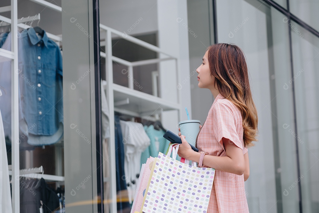 Mulher asiática cliente consumidora usando smartphone no shopping