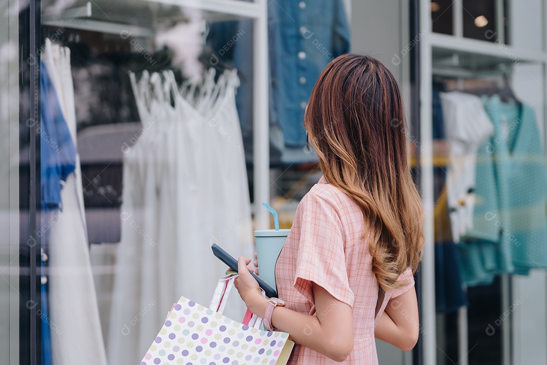 Mulher asiática cliente consumidora usando smartphone no shopping