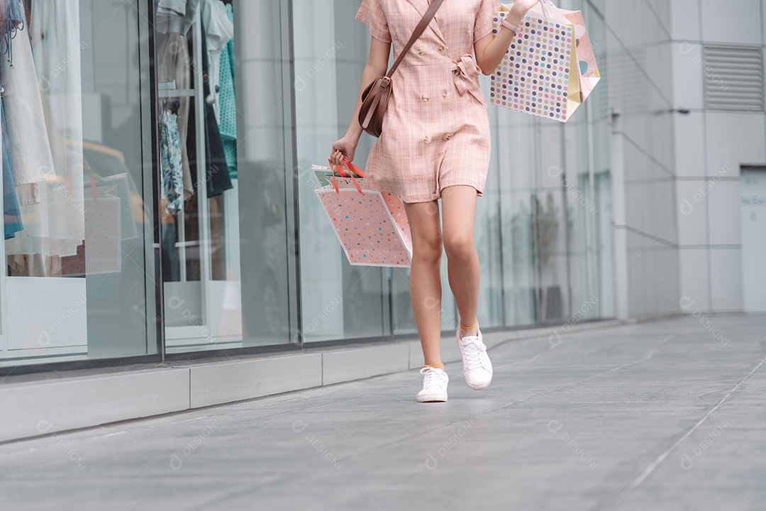 Linda mulher asiática segurando sacolas de compras