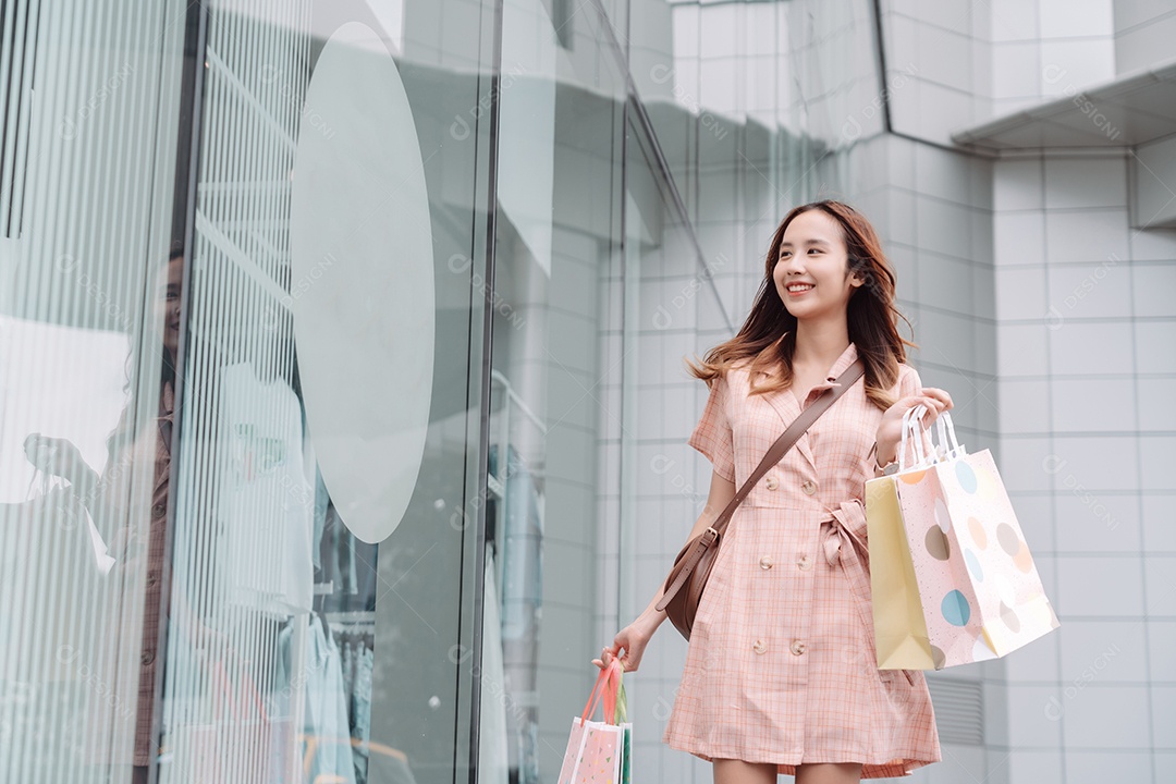 Linda mulher asiática segurando sacolas de compras