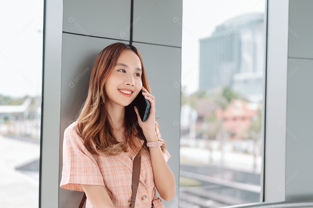 Mulher asiática adolescente usando smartphone no terminal do aeroporto