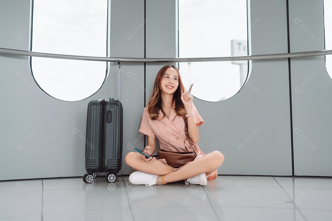 Mulher asiática adolescente usando smartphone no terminal do aeroporto