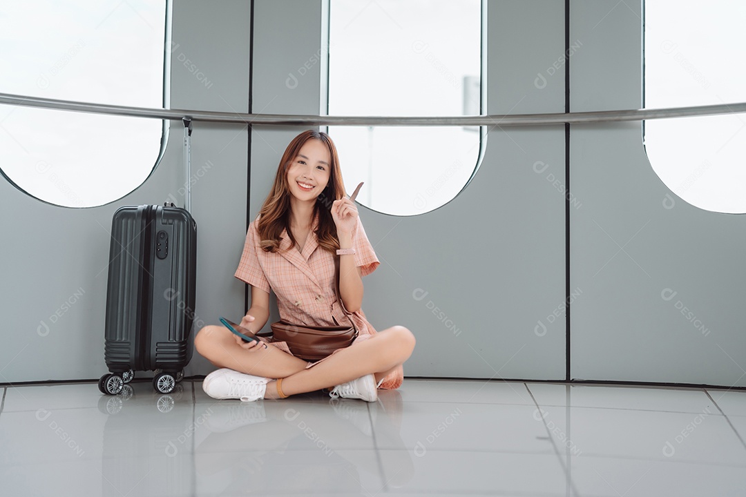 Mulher asiática adolescente usando smartphone no terminal do aeroporto