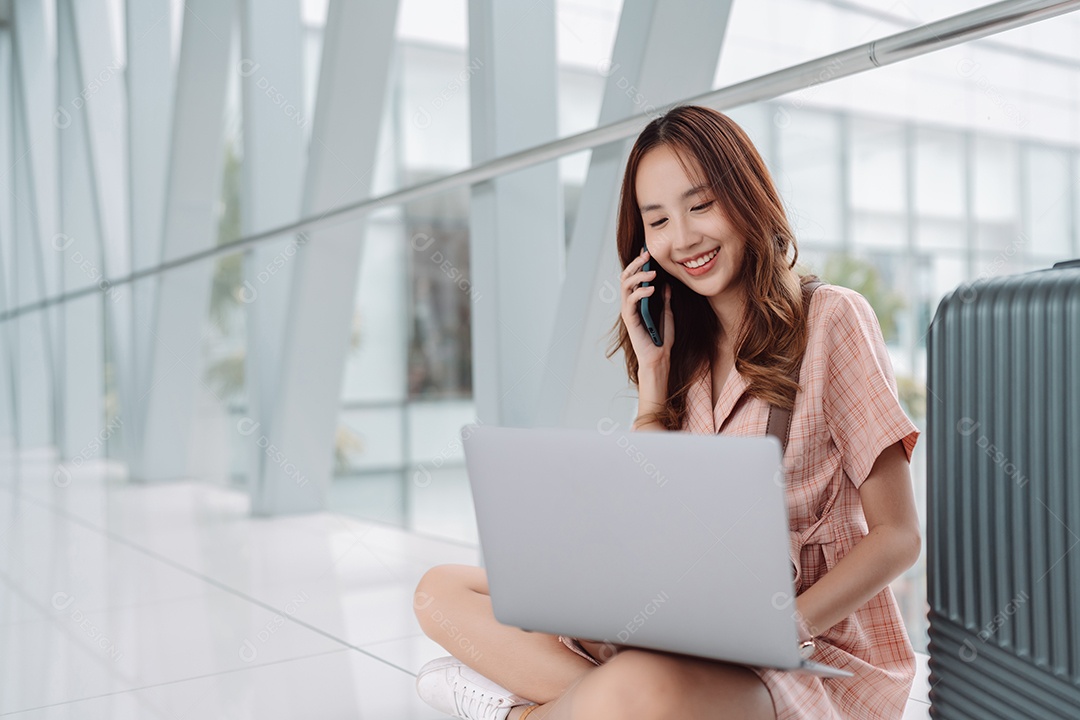 Mulher asiática adolescente usando laptop no terminal do aeroporto
