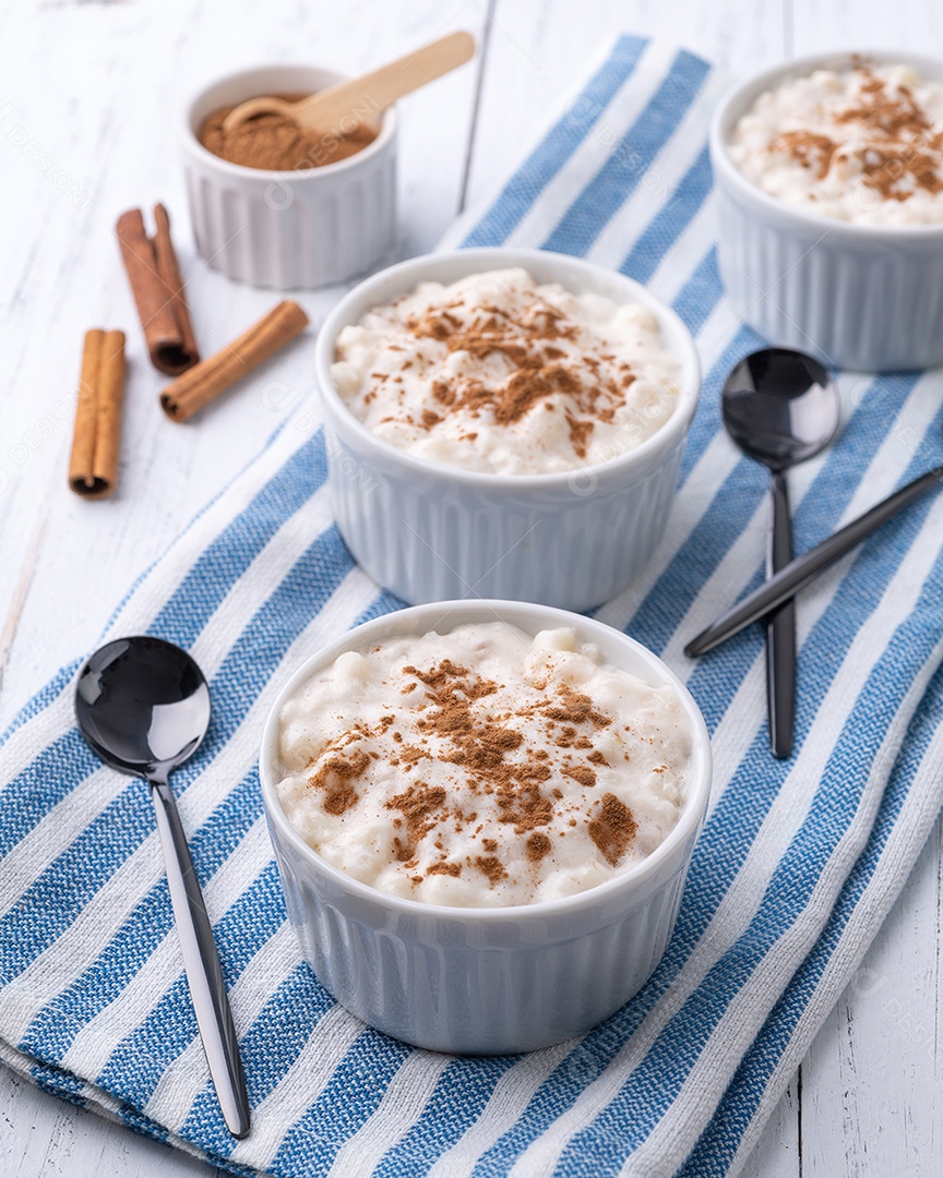 Canjica ou munguza, típico creme doce de milho branco brasileiro com canela sobre mesa de madeira.