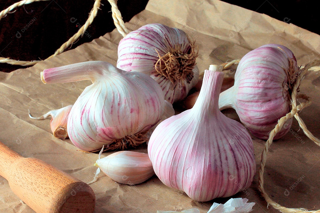 Bulbo de alho orgânico isolado sobre a mesa de cozinha de madeira rústica.