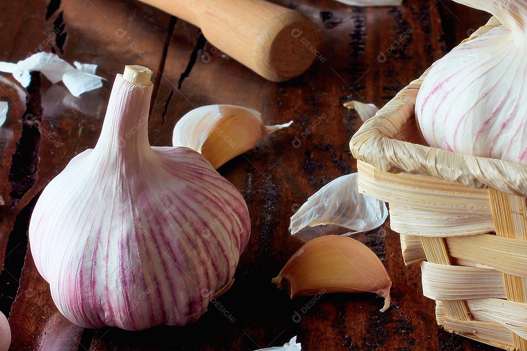 Bulbo de alho orgânico isolado sobre a mesa de cozinha de madeira rústica.