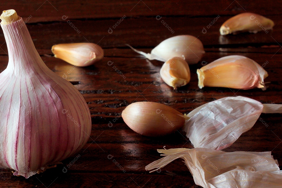Bulbo de alho orgânico isolado sobre a mesa de cozinha de madeira rústica.