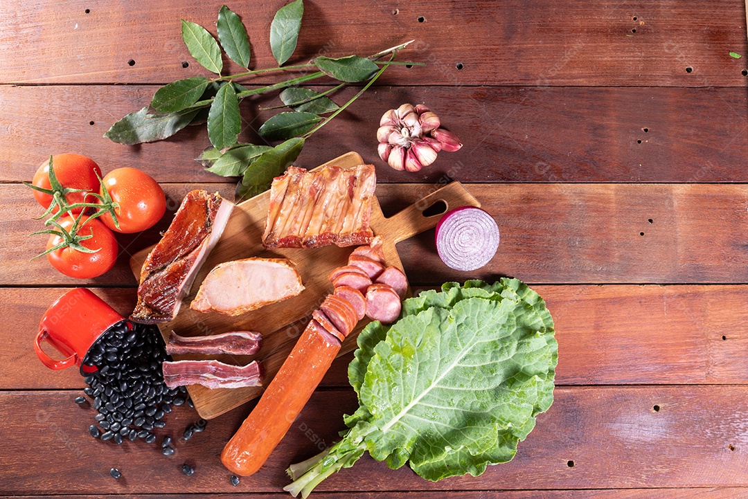 Ingredientes de feijoada sobre uma mesa de madeira