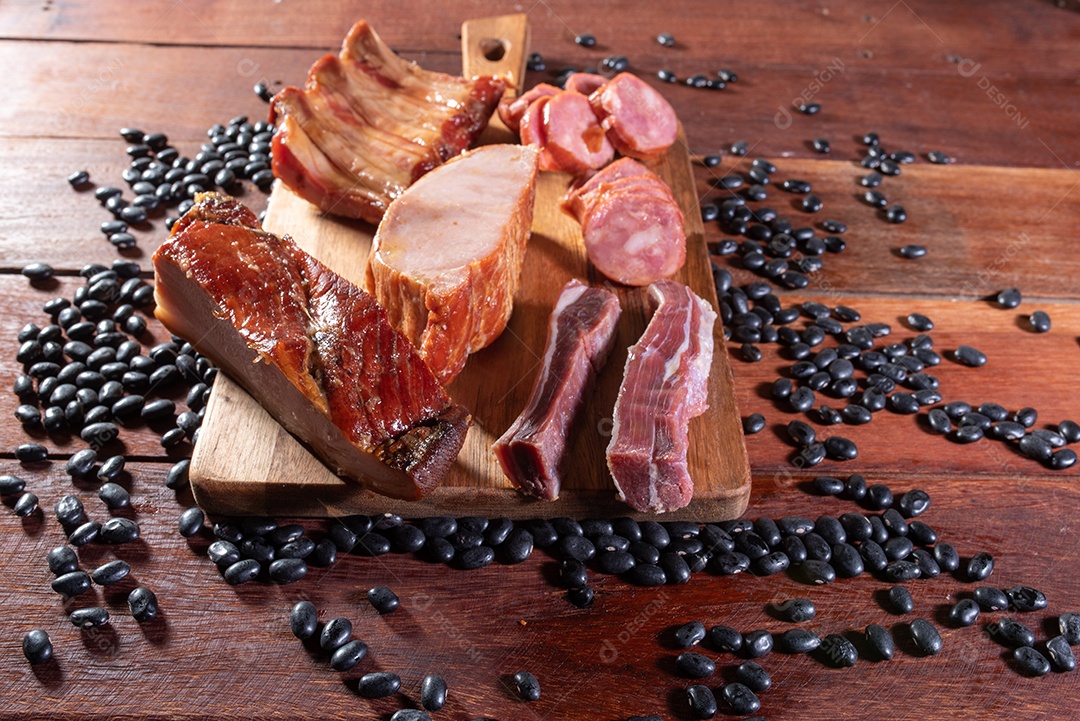 Ingredientes de feijoada sobre uma mesa de madeira