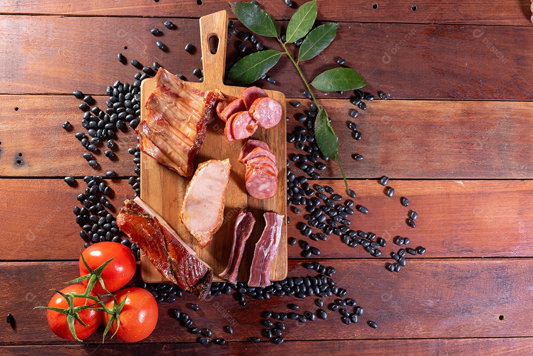 Ingredientes de feijoada sobre uma mesa de madeira