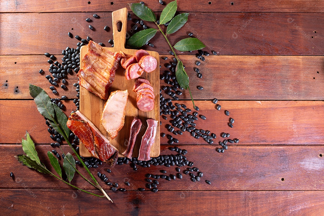 Ingredientes de feijoada sobre uma mesa de madeira