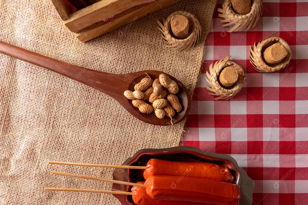 Mesa de madeira com comidas típicas da Festa Junina brasileira. espantalho
