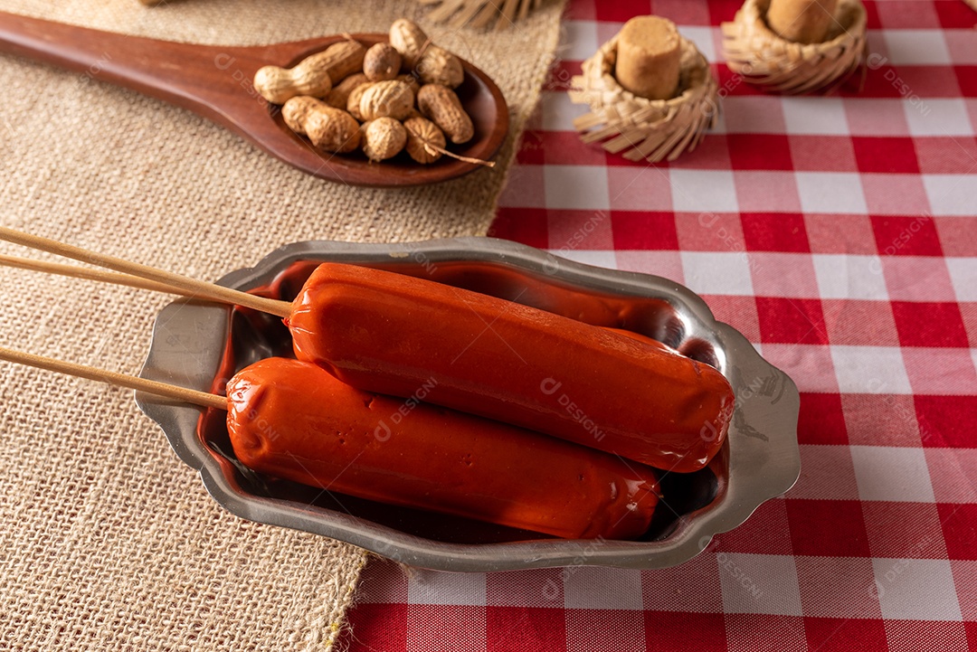 Mesa de madeira com comidas típicas da Festa Junina brasileira. espantalho
