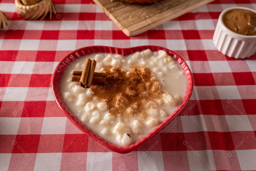 Mesa de madeira com comidas típicas da Festa Junina brasileira. espantalho