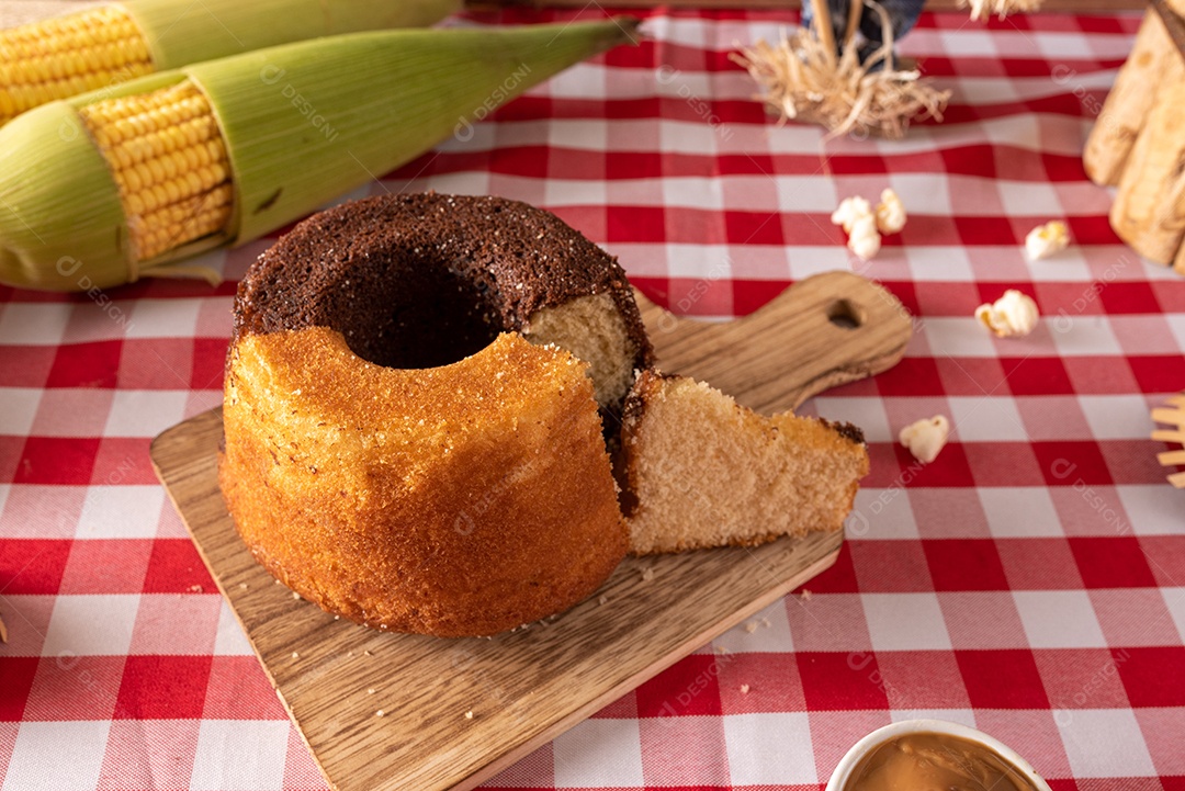 Mesa de madeira com comidas típicas da Festa Junina brasileira. espantalho