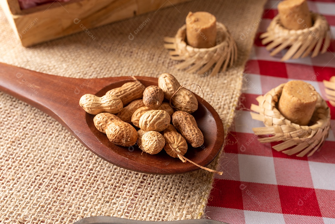 Mesa de madeira com comidas típicas da Festa Junina brasileira. espantalho