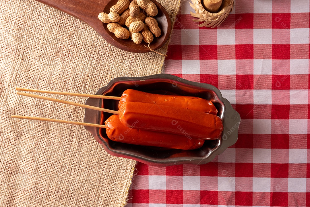 Mesa de madeira com comidas típicas da Festa Junina brasileira. espantalho