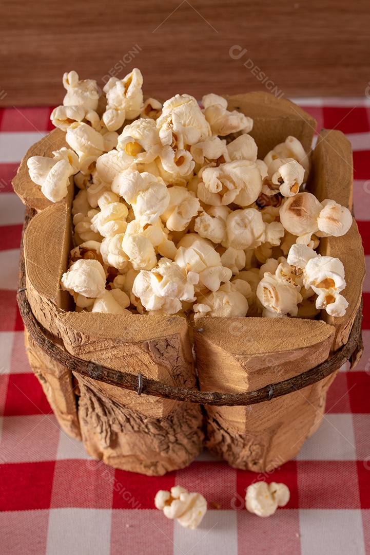 Mesa de madeira com comidas típicas da Festa Junina brasileira. espantalho
