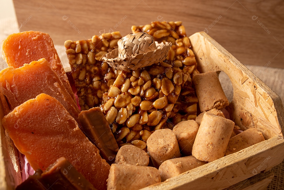 Mesa de madeira com comidas típicas da Festa Junina brasileira. espantalho