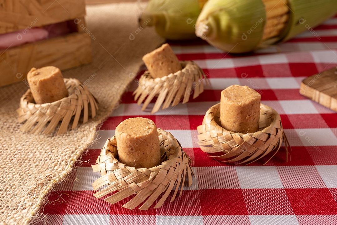 Mesa de madeira com comidas típicas da Festa Junina brasileira. espantalho