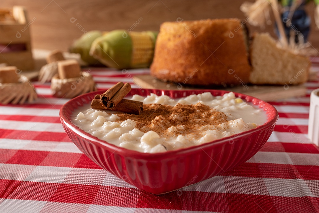 Mesa de madeira com comidas típicas da Festa Junina brasileira. espantalho