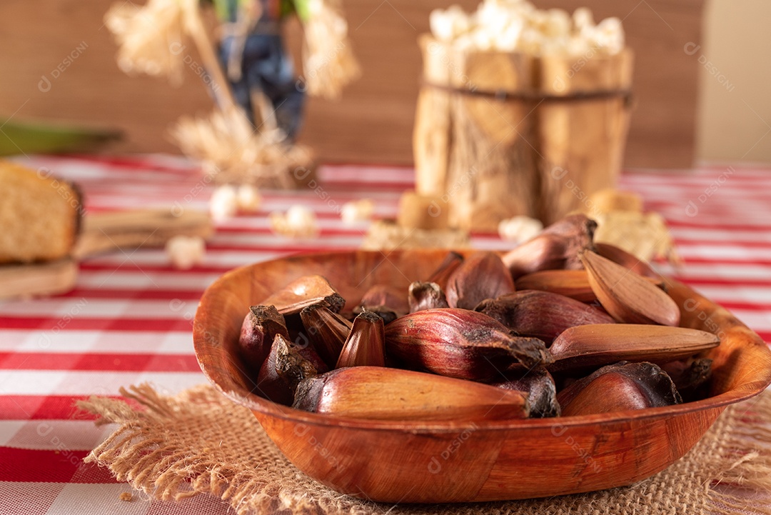 Mesa de madeira com comidas típicas da Festa Junina brasileira. espantalho