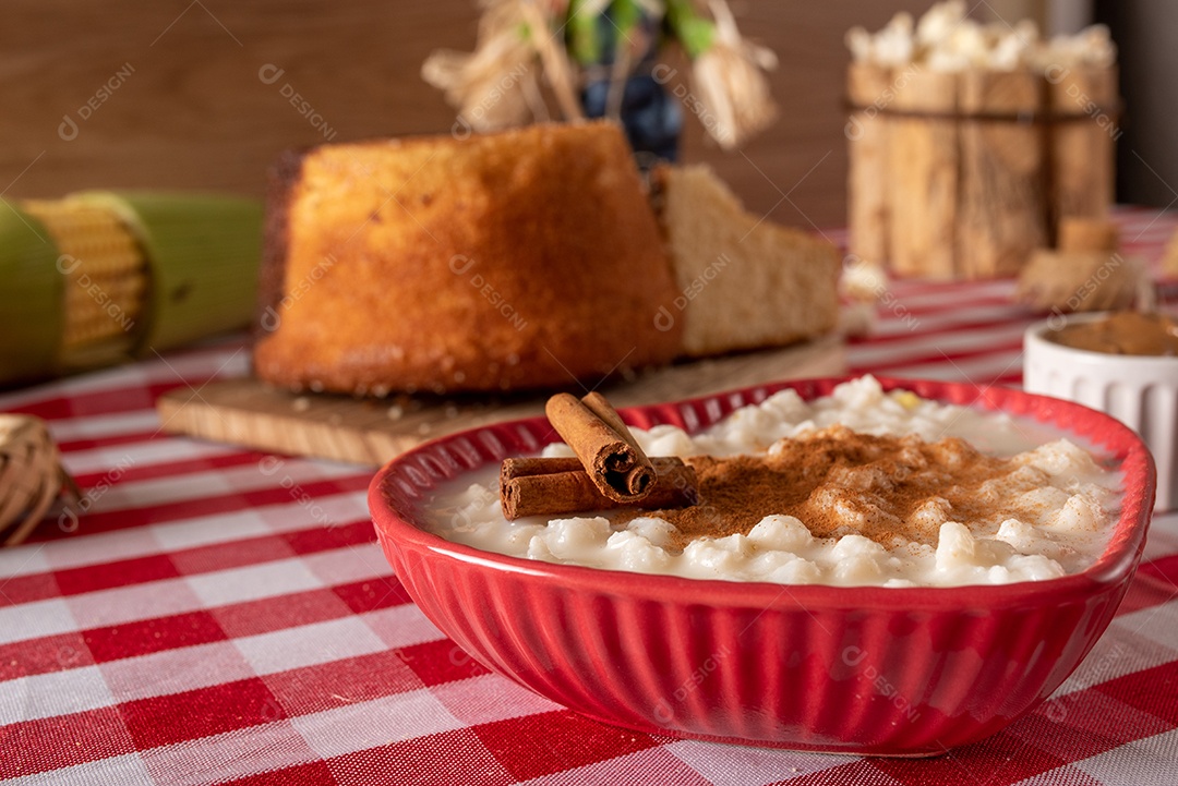Mesa de madeira com comidas típicas da Festa Junina brasileira. espantalho