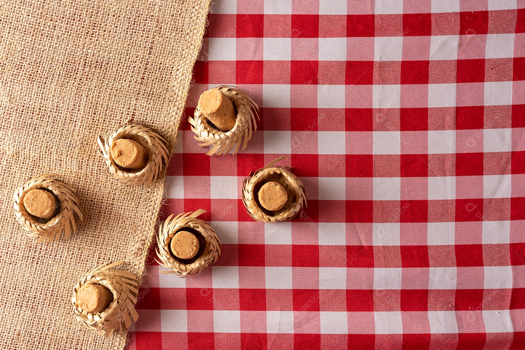Mesa de madeira com comidas típicas da Festa Junina brasileira. espantalho