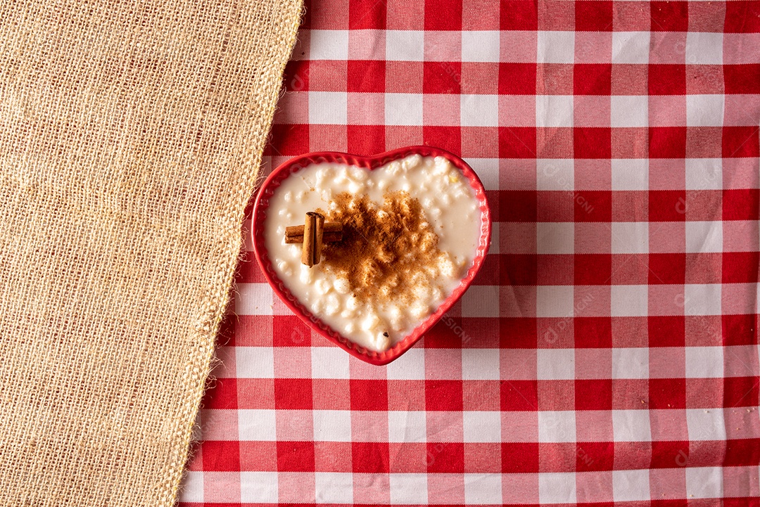 Mesa de madeira com comidas típicas da Festa Junina brasileira. espantalho