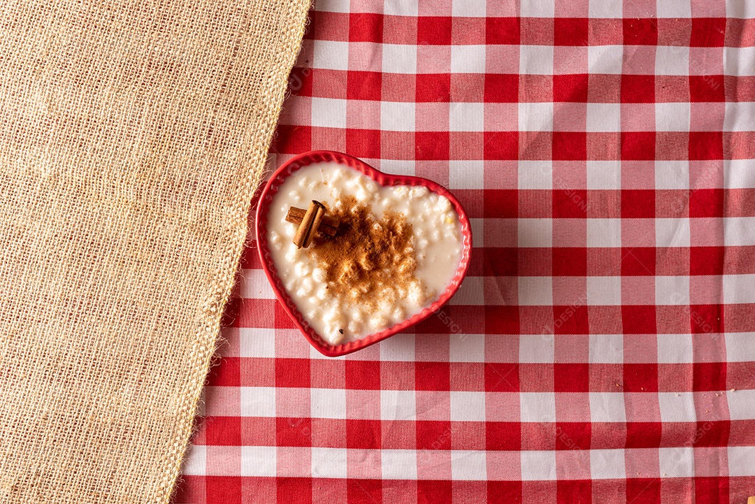 Mesa de madeira com comidas típicas da Festa Junina brasileira. espantalho