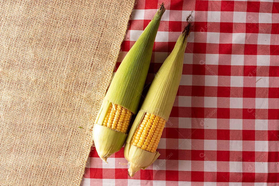 Mesa de madeira com comidas típicas da Festa Junina brasileira. espantalho
